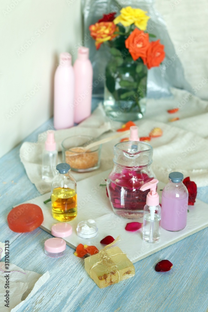 Fresh roses, petals, water and oil on the table for the preparation of natural cosmetics, spa treatments, healthy lifestyle