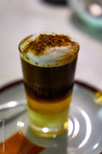 Special coffee of Canary islands, sweet barraquito coffee with layers and alcohol served in glass photo