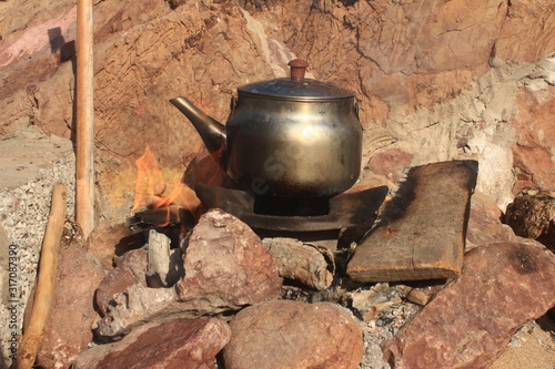 teapot on fire between stones