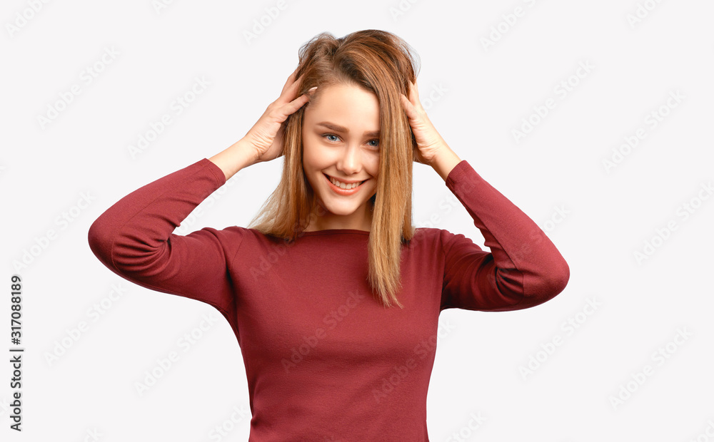 Girl makes volume of hair by lifting curls, flirting and laughing. Beautiful young woman with clean smooth skin wears Burgundy-colored jacket sleeves isolated on white background in Studio Girl makes volume of hair by lifting curls, flirting and laughing. Beautiful young woman with clean smooth skin wears Burgundy-colored jacket sleeves isolated on white background in Studio