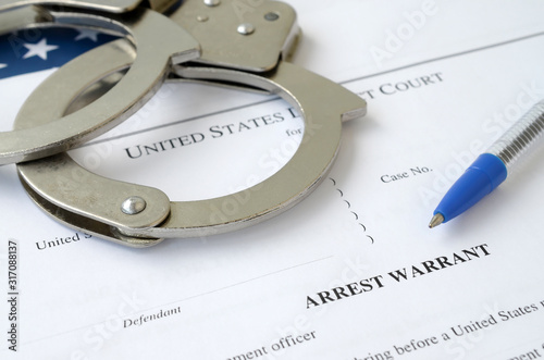 Billede på lærred District Court Arrest Warrant court papers with handcuffs and blue pen on United States flag