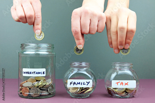 Hands putting in to different money jars. Spreading your inheritance money around concept. photo