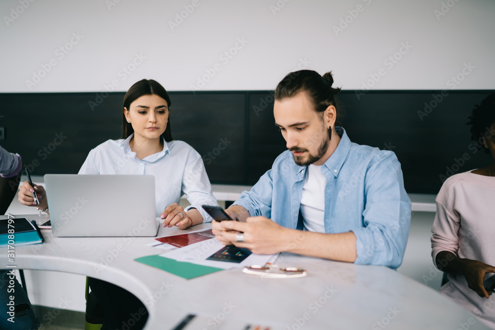 Office workers using gadgets while working together at project Office workers using gadgets while working together at project