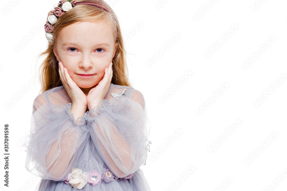 Little fashionable red-haired girl in a gray dress with a wreath on her head posing on a white background Little fashionable red-haired girl in a gray dress with a wreath on her head posing on a white background