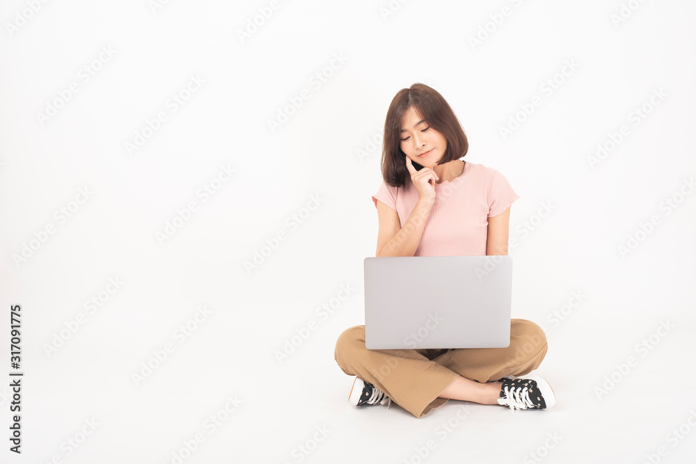 Cute Asian teen woman is working with computer on white background Cute Asian teen woman is working with computer on white background