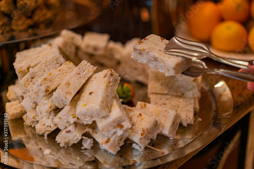 Egyptian semolina cake with nuts and syrup. Eastern cookies Basbousa -beautifully served on metal plate. Traditional desert in Egypt. photo