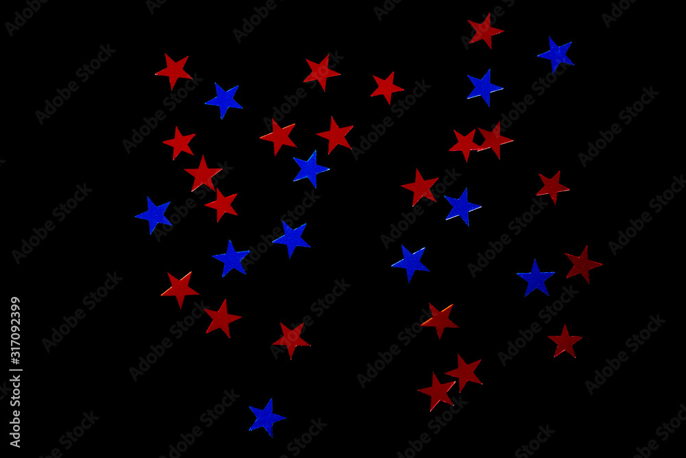 a scattering of blue and red sequins in the shape of stars, isolate on a black background a scattering of blue and red sequins in the shape of stars, isolate on a black background
