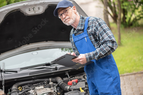 Car mechanic checking a car engine
