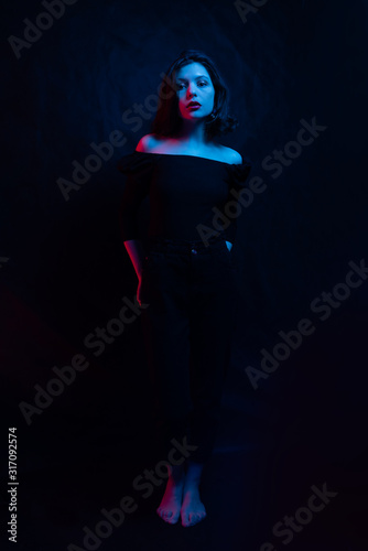Fashion portrait girl light neon Blue and red. woman in colorful lights on Black background. Beautiful sexy girl with trendy make-up