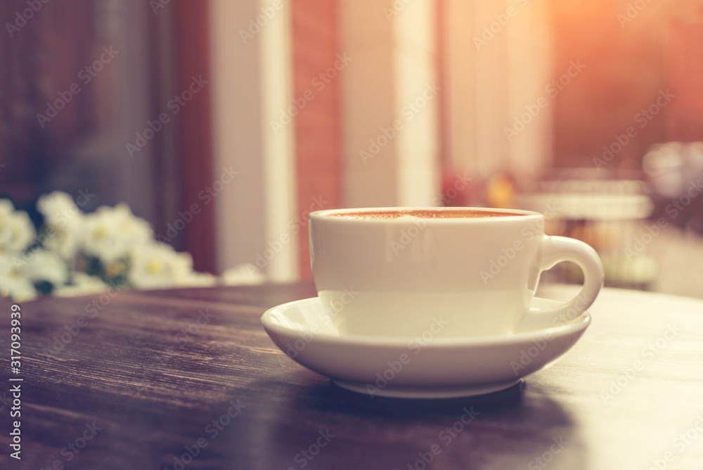 View of a summer terrace cafe with cup of cappuccino on the table. View of a summer terrace cafe with cup of cappuccino on the table.