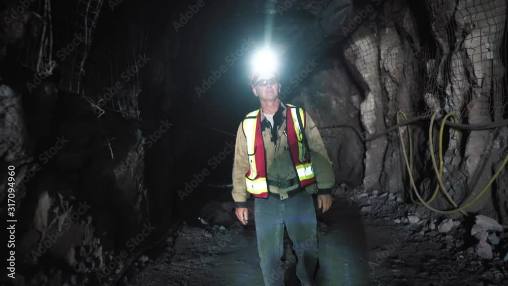 A miner goes through an underground section in the mine. He inspects the chips. He wears a safety helmet, a reflective vest, with a self-rescue vest. It's all for safety. A miner goes through an underground section in the mine. He inspects the chips. He wears a safety helmet, a reflective vest, with a self-rescue vest. It's all for safety.