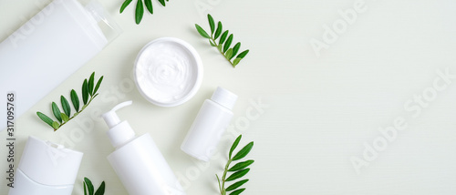 Natural organic SPA cosmetic products set with green leaves. Top view herbal skincare beauty products on green background. Banner mockup for eco shop or beauty salon. Flat lay minimalist style