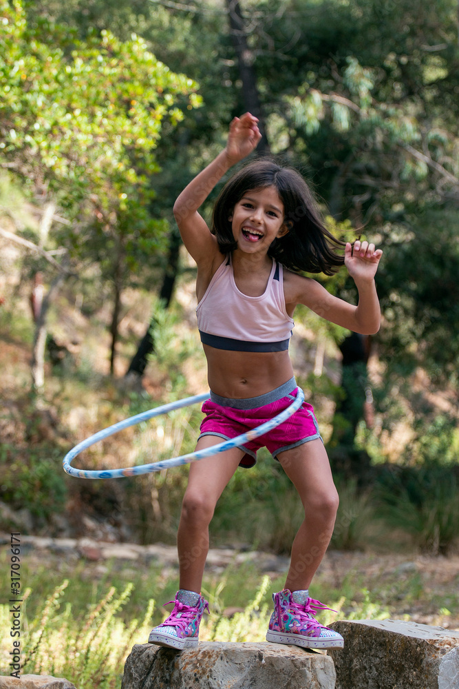 Cute girl posing with hula hoop foto de Stock | Adobe Stock