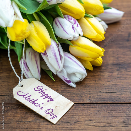 Happy Mother's Day background square - Bouquet of yellow and white tulips with a pendant on a rustic wooden table