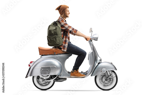 Guy with hat and backpack riding a vintage motorbike