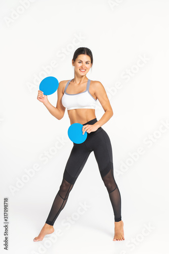 sporty woman 30s posing with fitness disks at white background