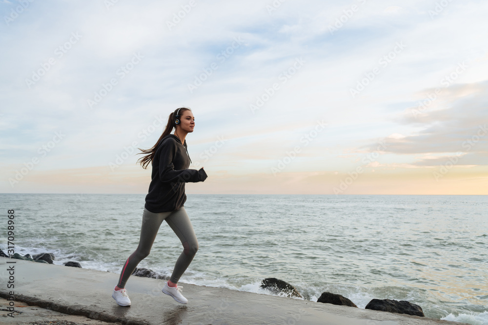 runner in sportswear on the background of the sea and sunset runner in sportswear on the background of the sea and sunset