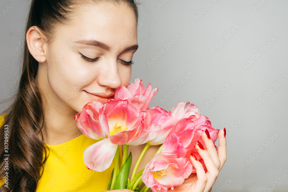 girl with pleasure sniffs tulips covering her eyes girl with pleasure sniffs tulips covering her eyes