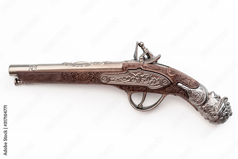 Firearms dating to the american revolution and antique collectables concept with ornate old fashioned dueling flintlock pistol isolated on white background with clipping path cutout