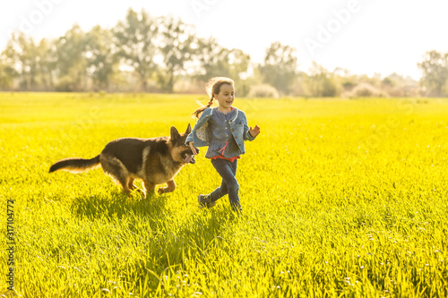 Little girl with dog running on the road © Angelov