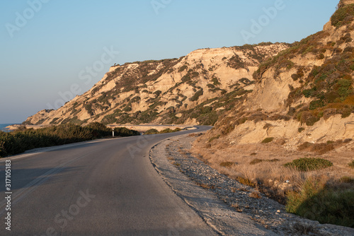 The road between mountains and sea. Sunset in Greece and lonely winding road. © Nikkeero