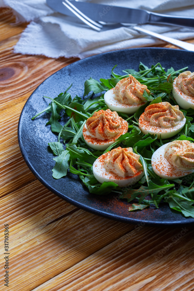 Deviled eggs with paprika on fresh arugula salad Deviled eggs with paprika on fresh arugula salad