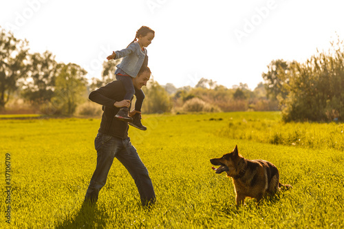 Father and toddler walking with dog © Angelov
