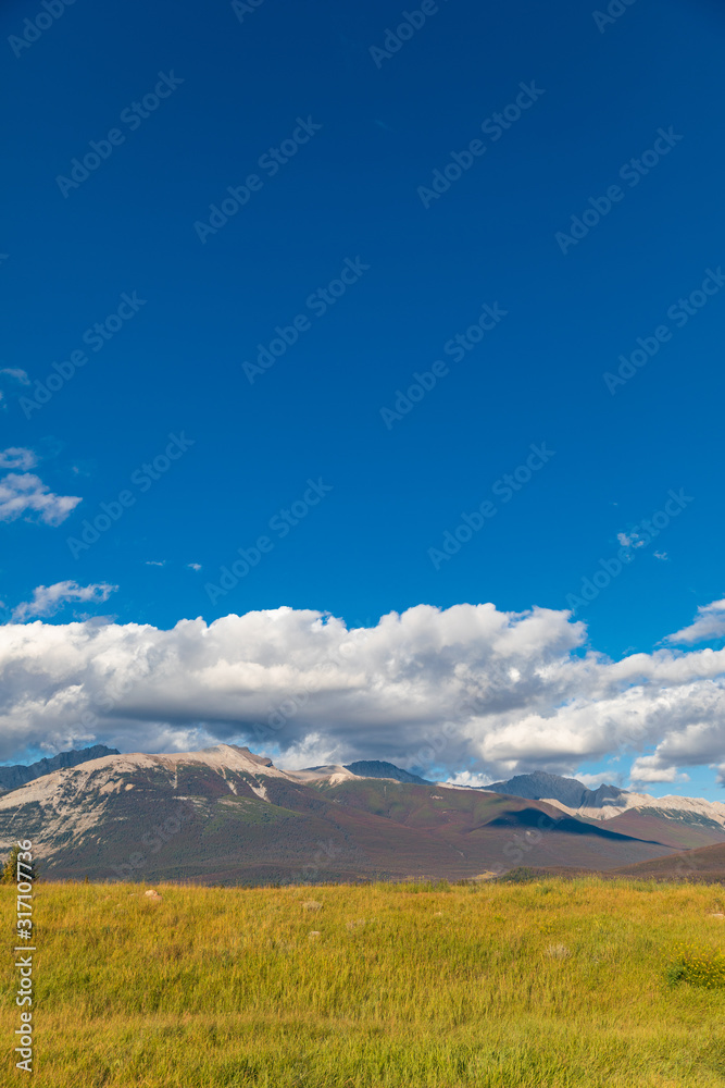 blue sky clouds and mountain over grassland
