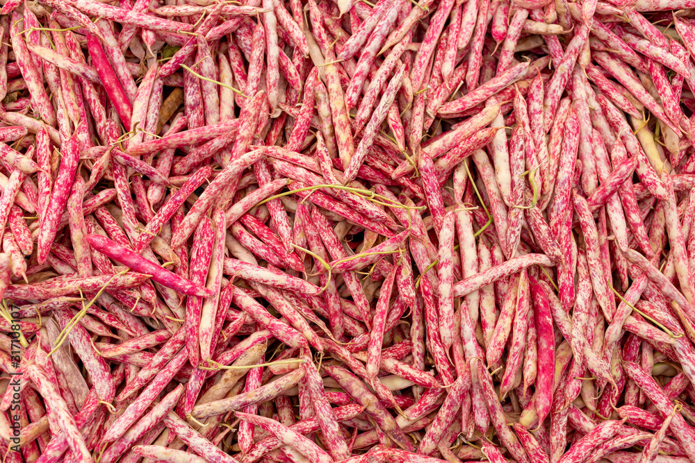 Fototapeta premium A table is filled with cranberry beans for sale at a market