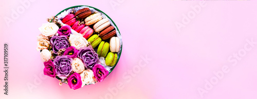 Festive concept from rosebuds in full bloom and Multicolored Macaroons on pink background. Valentines Day. Template mock up of greeting card or text design. Close-up