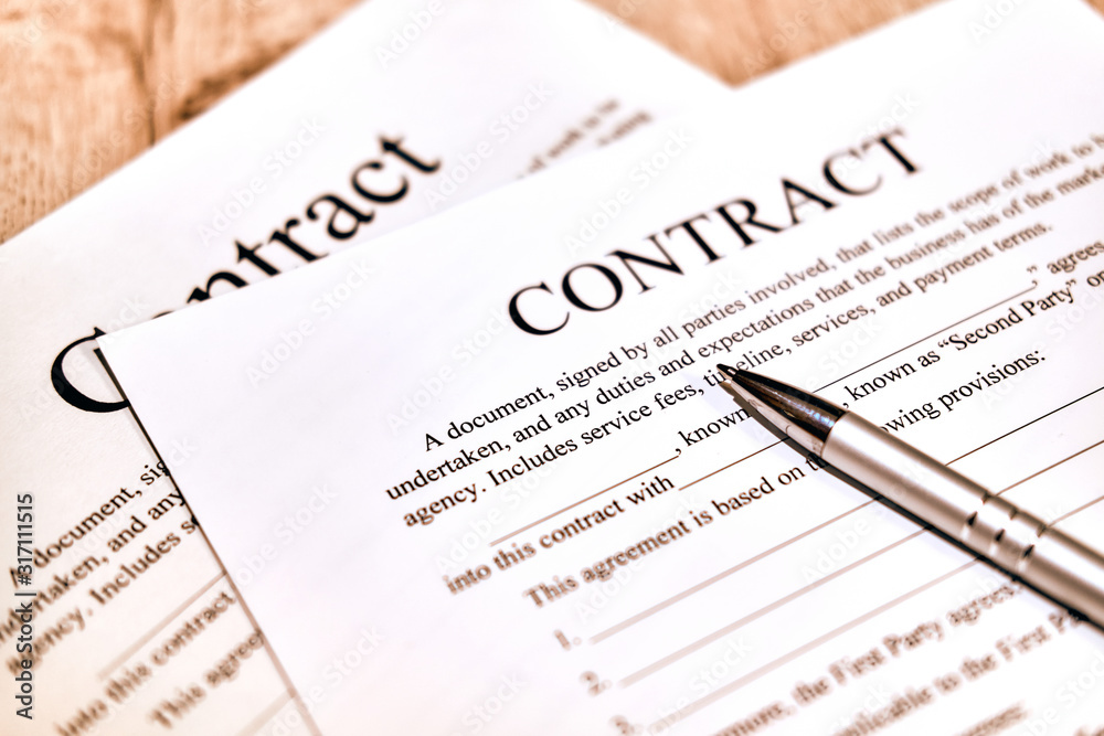 Contract sheet with a pen on a wooden background Contract sheet with a pen on a wooden background