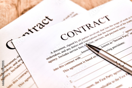 Contract sheet with a pen on a wooden background