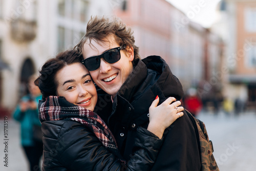 Smiling couple in love outdoors. Young happy couple hugging on the city street