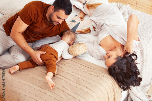 young happy family together having fun in bed, lifestyle people concept at home
