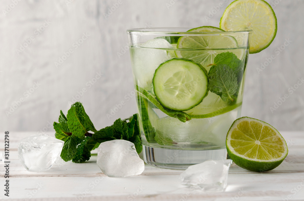 Infused water on a glass. Detox water mix of cucumber, lemon, lime and mint. Infused water on a glass. Detox water mix of cucumber, lemon, lime and mint.