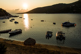 Boats parking in the Mediterranean sea bay, golden light scenery during morning sunrise