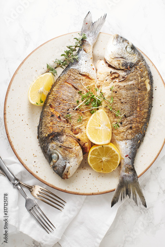 Cooked dorado fish with lemons and herbs