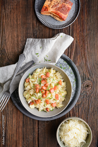 Kapustove halusky known as Strapacky, classic dish in Slovakia, boiled potato dumplings with sauerkraut and onion, topped with fried bacon and fresh chives photo