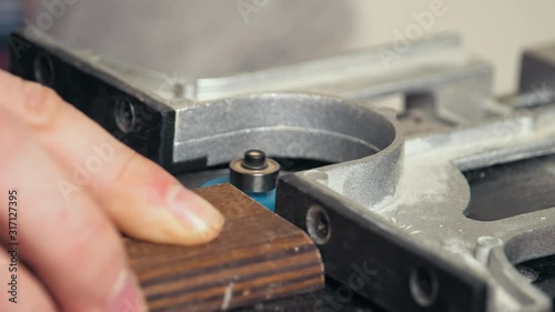 Wallpaper Mural Close-up of the carpenter's hands chamfering the edge of the Board made of glued plywood, the milling cutter works on a small wooden plank with a large amount of sawdust. Torontodigital.ca