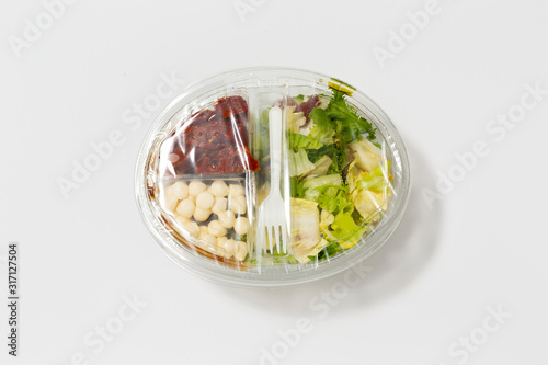 Use less plastic! Food in plastic packaging isolated on white ground. Symbol for environmental pollution done by the food industry