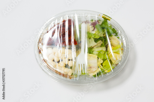 Use less plastic! Food in plastic packaging isolated on white ground. Symbol for environmental pollution done by the food industry