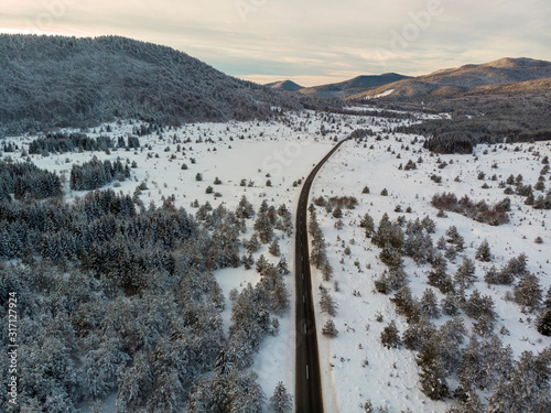 Aerial view of the road during winter with snow on dusk. Lika  Croatia