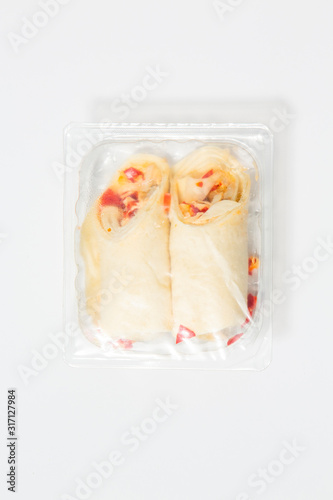 Use less plastic! Two wraps in plastic packaging isolated on white ground. Symbol for environmental pollution done by the food industry