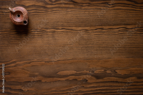 Roman oil lamp on wooden background