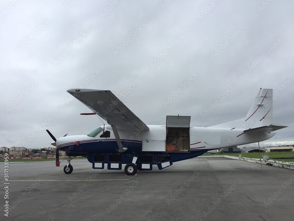 Turboprop cargo plane parked in airport yard being loaded on cloudy day Turboprop cargo plane parked in airport yard being loaded on cloudy day