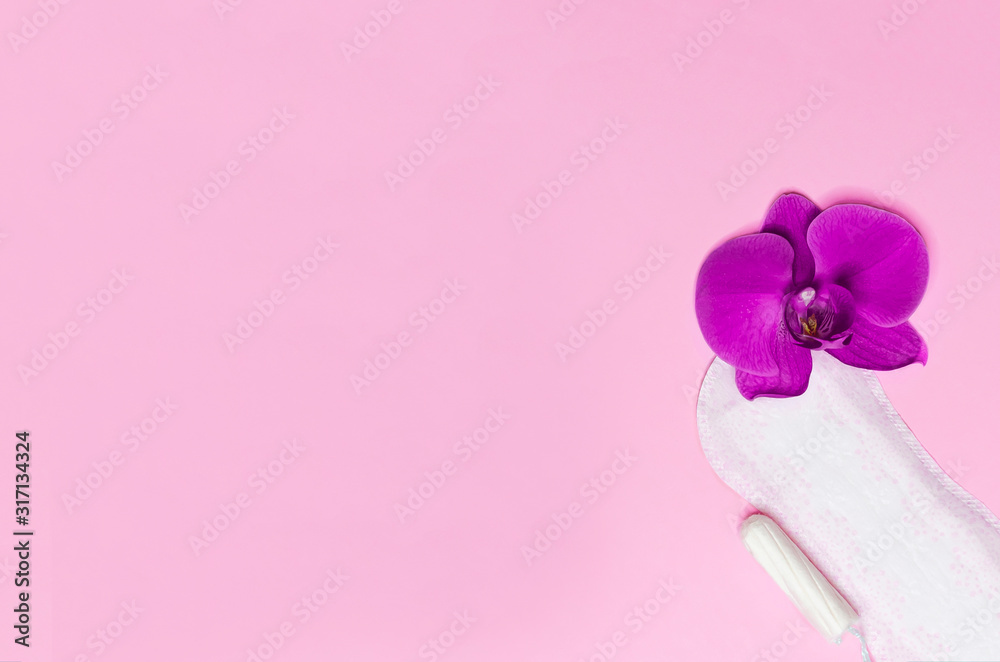 daily sanitary pad and tampon on critical days for a woman during menstruation on pink background with purple orchid flower. hygiene and care. copy space, text daily sanitary pad and tampon on critical days for a woman during menstruation on pink background with purple orchid flower. hygiene and care. copy space, text