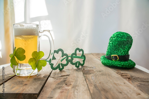 St. Patricks Day green shamrocks with a full cold frosty glass of beer   background