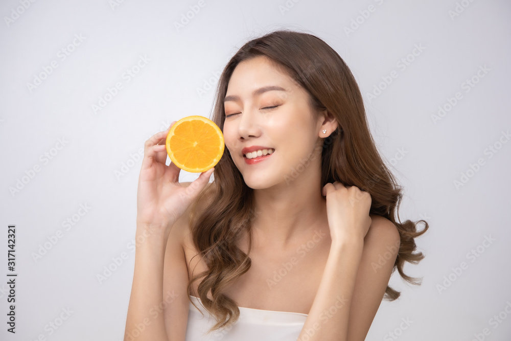 Beautiful Young Asian Woman short hair with Clean Fresh Skin. Face care, Facial treatment, Cosmetology, beauty and healthy skin and cosmetic ideas concept.pretty woman holding half of orange . Beautiful Young Asian Woman short hair with Clean Fresh Skin. Face care, Facial treatment, Cosmetology, beauty and healthy skin and cosmetic ideas concept.pretty woman holding half of orange .