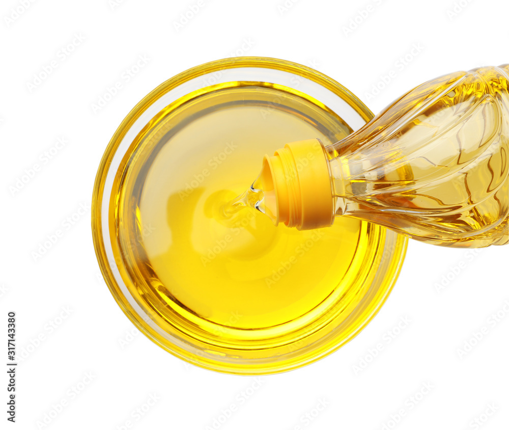 Pouring cooking oil from bottle into bowl isolated on white, top view