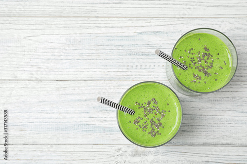 Tasty kale smoothie on white wooden table, flat lay. Space for text